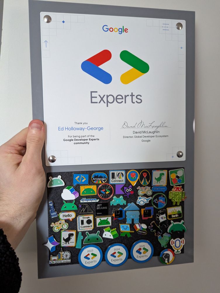 A Google Developer Expert branded pin board covered in multiple pin badges
