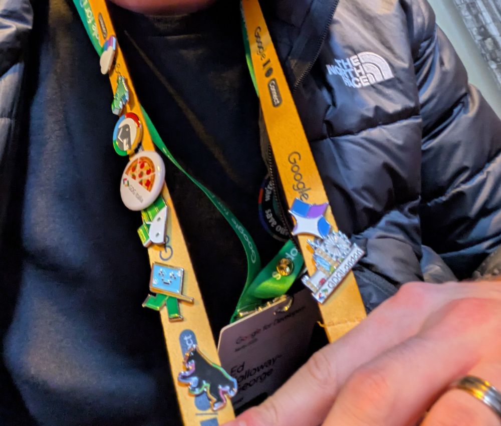 A lot of custom Google IO Connect pins on a yellow lanyard