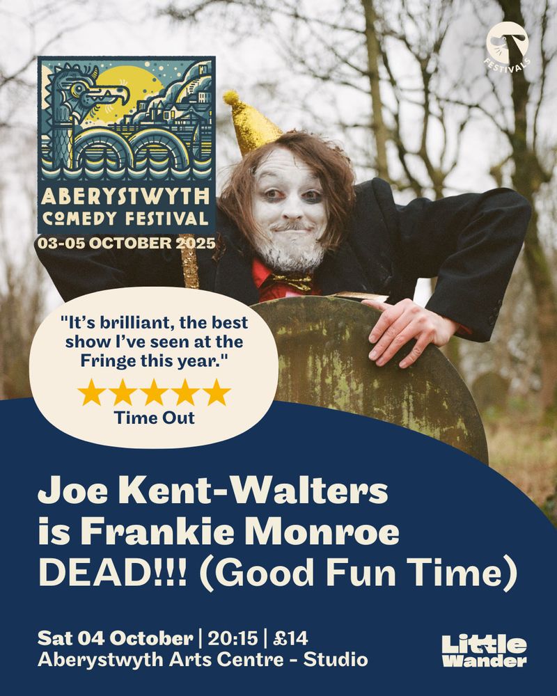 A photo of the comedian Joe-Kent Walters, promoting his comedy show 'DEAD! Good fun time!'. He is partially hiding behind a gravestone, with his head, sholders, and arms peering over the top. He has white face paint and is pulling a silly face. He is holding a cane, and wearing a gold pointy party hat. He's wearing a black suit and a red shirt.