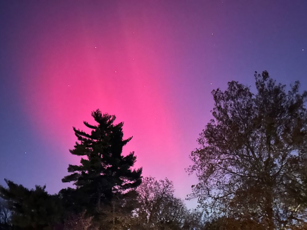 Picture of night sky with hot pink light from the Northern Lights
