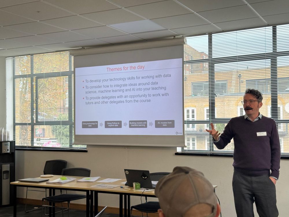 A presenter stood by a screen