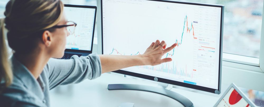 A data scientist pointing at some data on a screen.