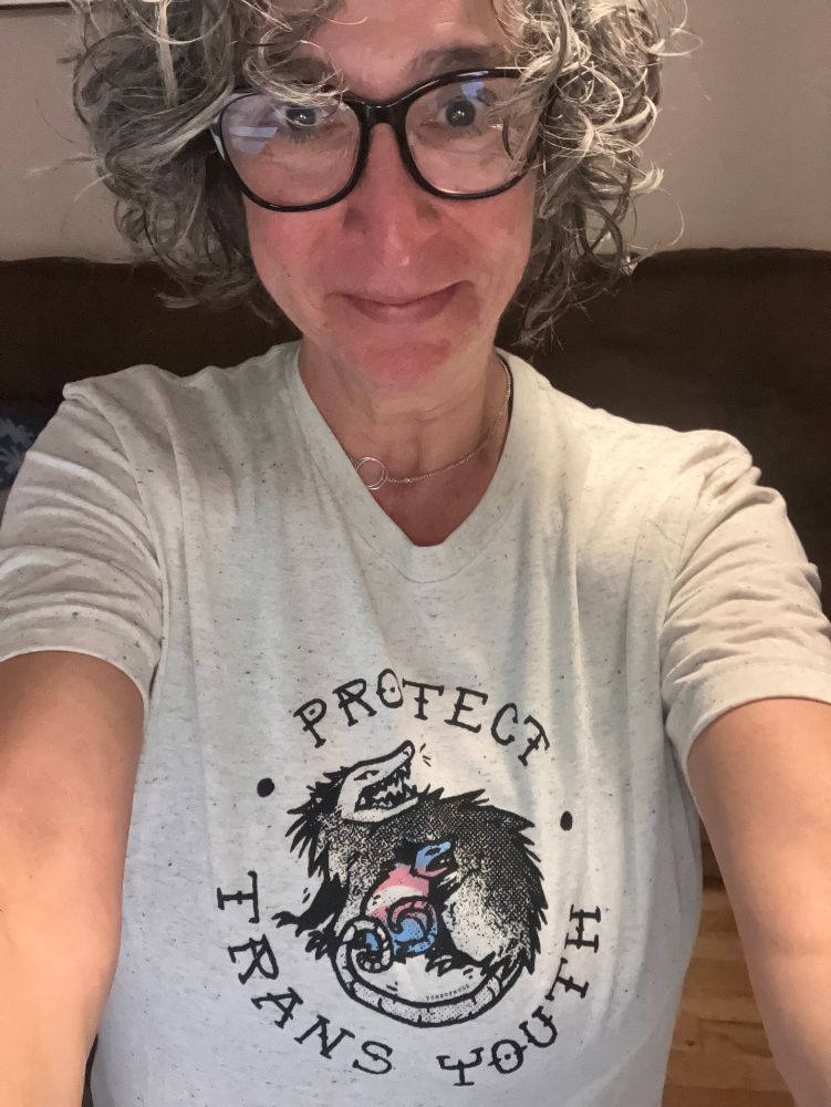 Self of me in my new Protect Trans Youth t-shirt featuring an angry possum protect a trans youth possum. 