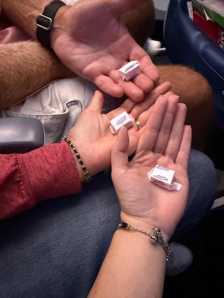 me mom and dad’s hands all holding a piece of bubbleyum