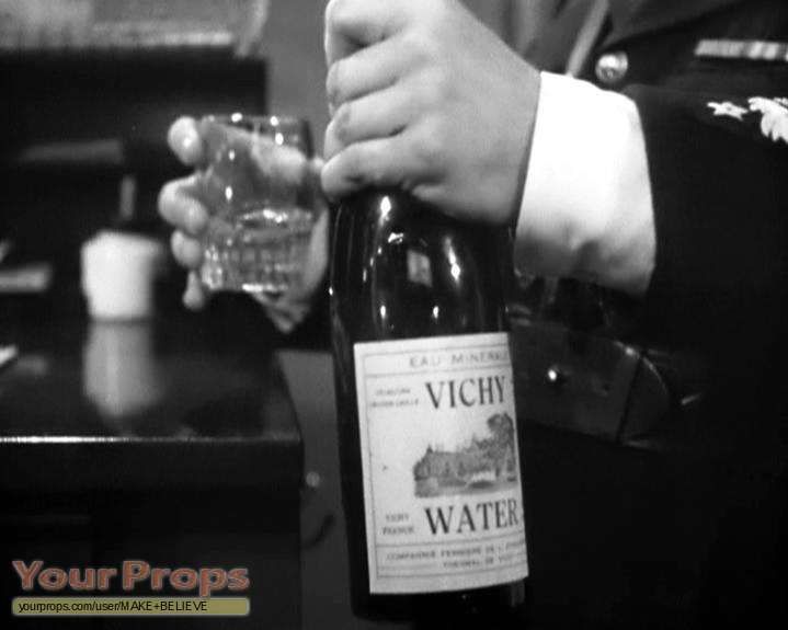 A hand holding a bottle of Vichy water.