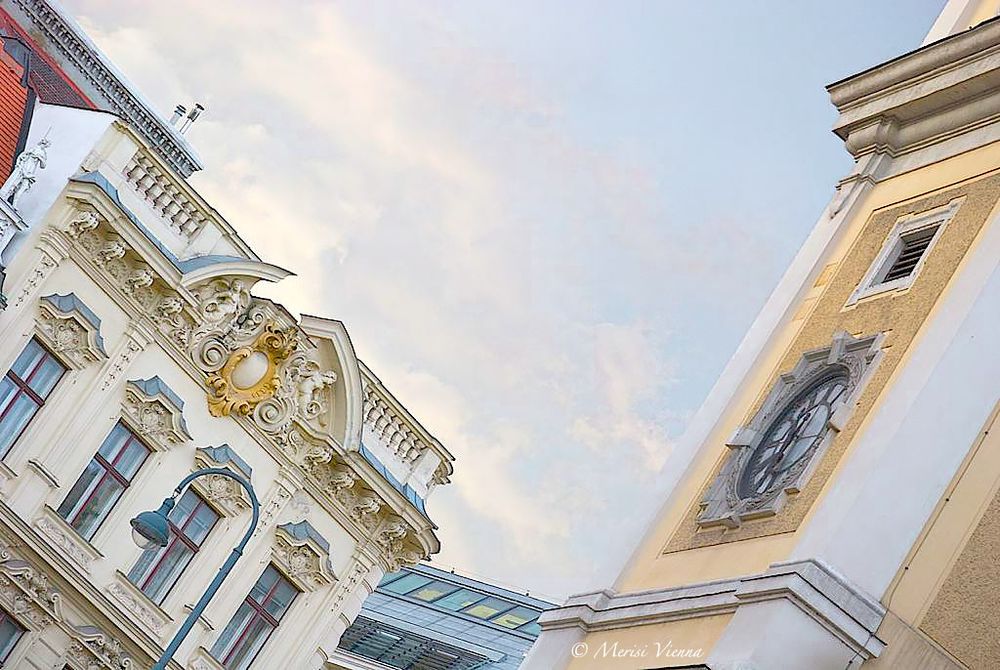 Façade of a building to the left and part of a clock tower to the right
