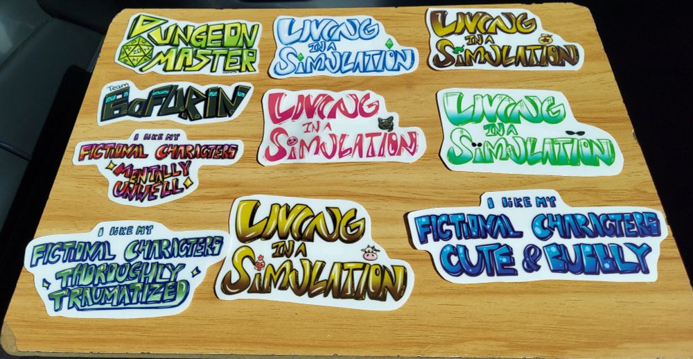 Top to bottom from left to right

Row 1: Dungeon Master with D20 dice between D and M

Living in a simulation with Is dotted with the Sims diamonds. 

Living in a simulation with Is dotted with animal crossing bell bag and leaf.

Row 2:
Team Bofurin

I like my fictional characters *mentally unwell*

Living in a simulation based on slime rancher colors.

Living in a simulation based on the matrix colors.

Row 3

 I like my fictional characters *thoroughly traumatized*

Living in a simulation with a cow and chicken dotting the Is.

I like my fictional characters *cute and bubbly*