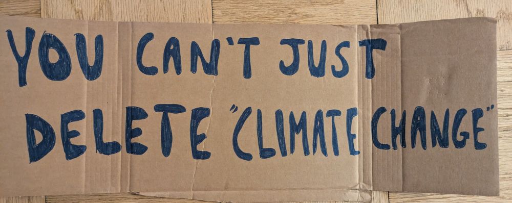 Cardboard sign "you can't just delete "climate change" "