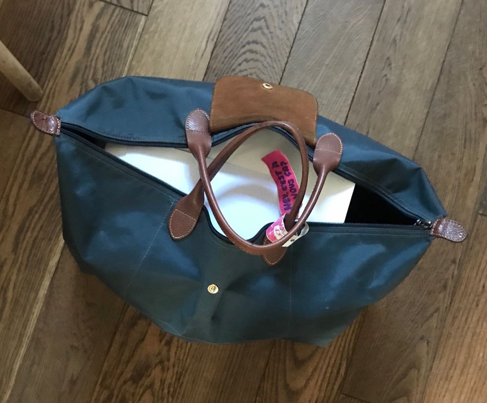 Blue waxed canvas bag with leather handles.