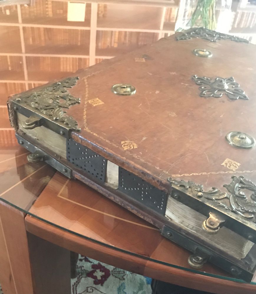 Tan calf gilt binding with a lot of brass furniture. On a round table.