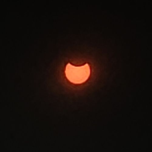 A picture of the moon passing above the Sun (at its peak) and partially eclipsing it.