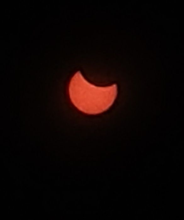 A picture of the Sun with the moon partially eclipsing it from above. 