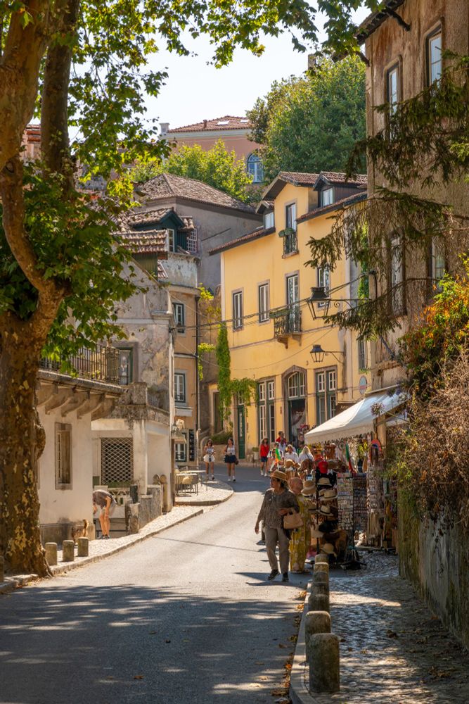 Wandering through the charming streets of Sintra, Portugal — where colorful buildings, cobbled paths, and shaded alleys create a picture-perfect summer stroll.