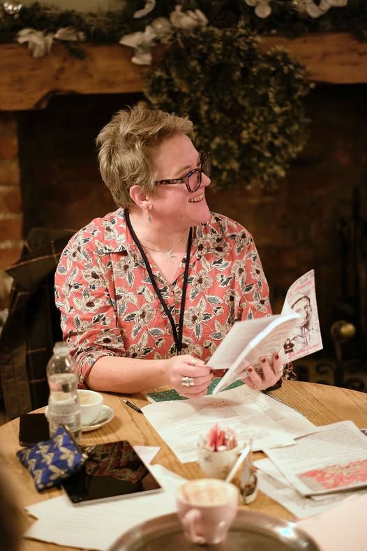 Me in a red flowery shirt reading a monologue and grinning like a Cheshire Cat