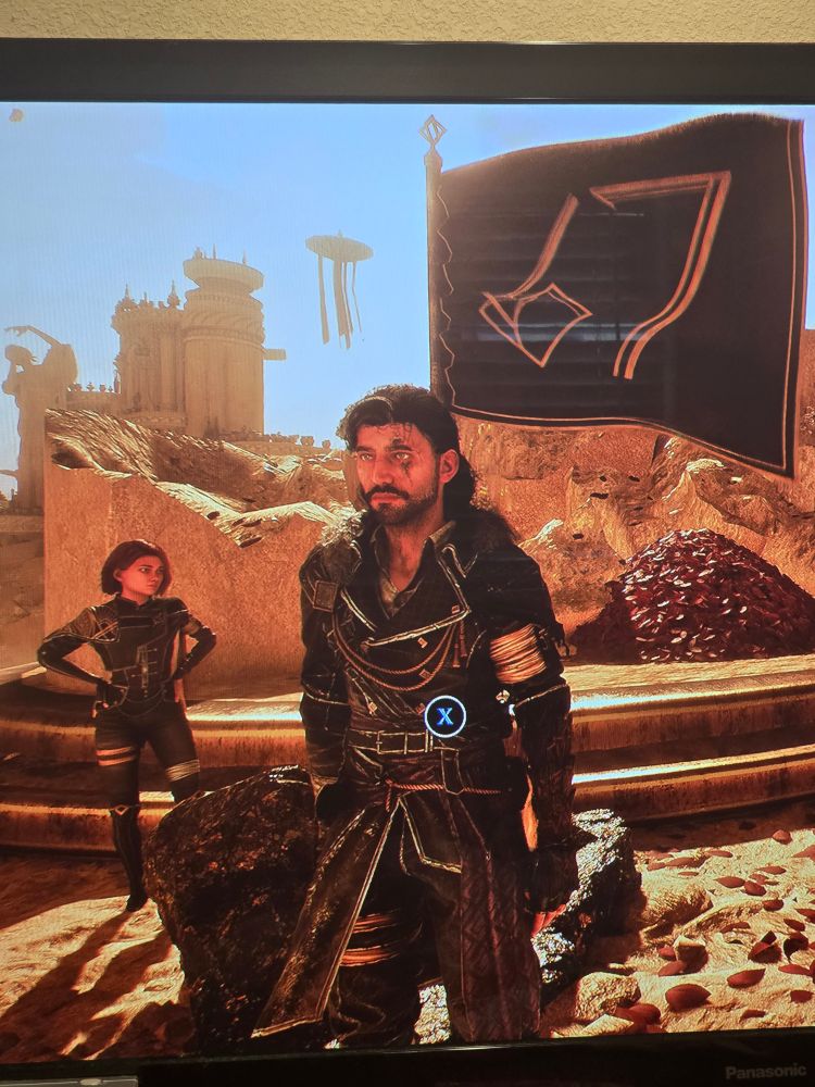 Verso from Clair Obscur -Expedition 33 standing in front of a flag displaying "67", with Maelle behind him with her hands on her hips looking disappointed