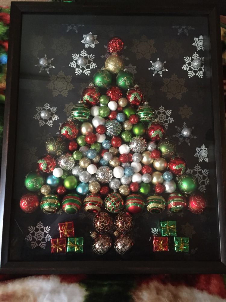 A shadow box Christmas tree made with lots of small ornaments, wrapping paper, and hot glue 