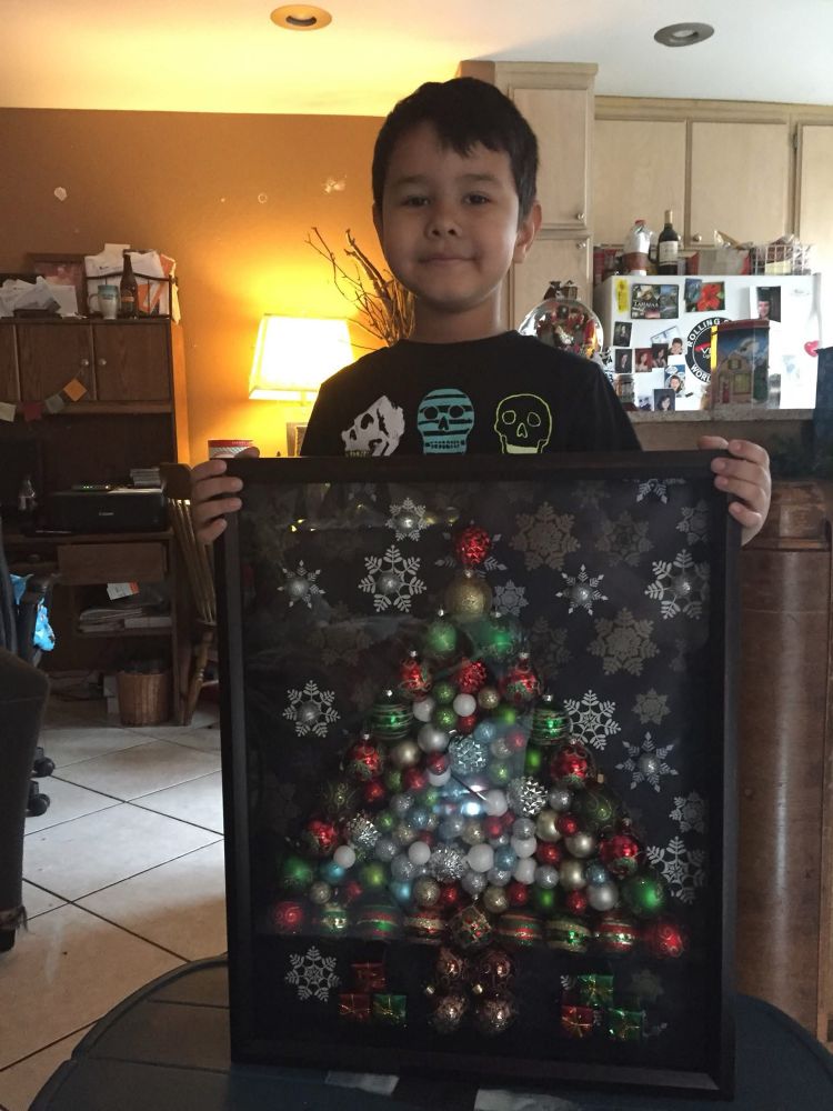 My grandson Damian holding the completed shadow box Christmas tree. 