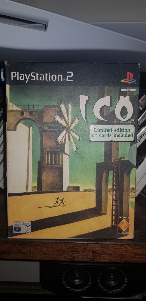 Ico, classic PS2 videogame. Original box with alternate cover shows two figures running through a desolate landscape littered with almost abstract structures.