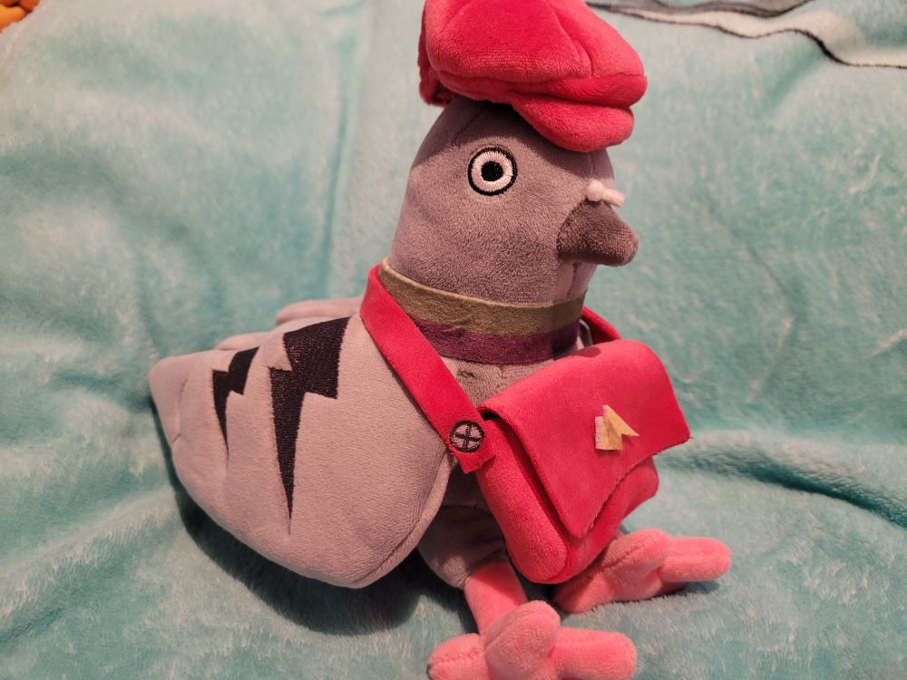 Pot-chan from Sushi Ben plush. A pigeon wearing a red mailbag and hat.