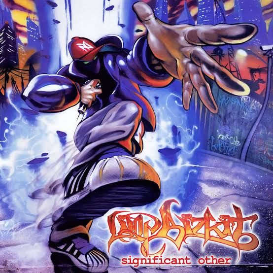 Cover art of the album Significant Other by Limp Bizkit. A person in an urban environment dressed in loose clothing, sneakers, baseball cap and a face covering mask holds a microphone in one hand and gestures dranatically towards the audience with the other. This character is featured in several other artworks for the band 