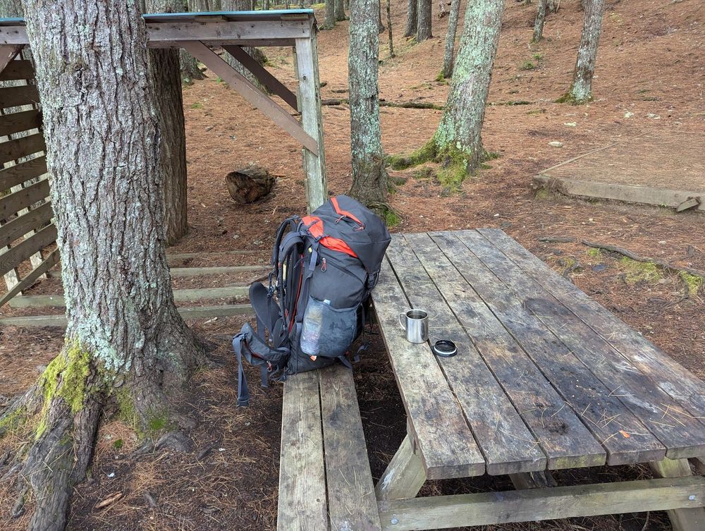 Camping gear on a picnic table at Keji, with a coffee cup in the foreground.