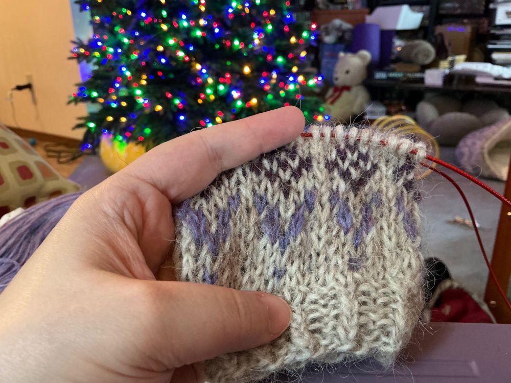 Knitting project in process - beige sweater with purple colorwork on the cuff.