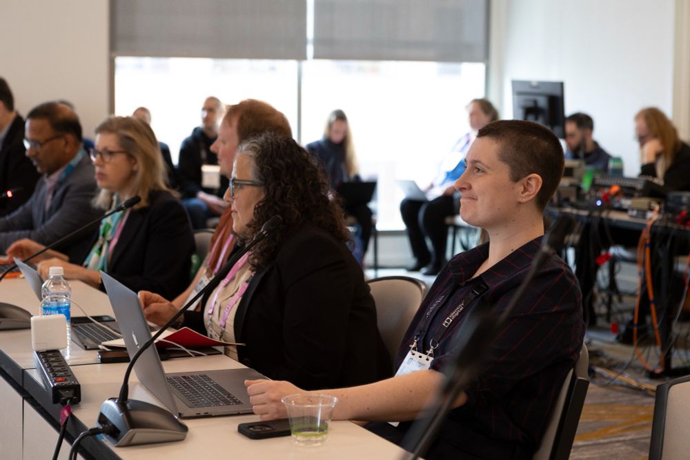 A photo of Bridget Chase and others sitting on a panel at ICANN 82