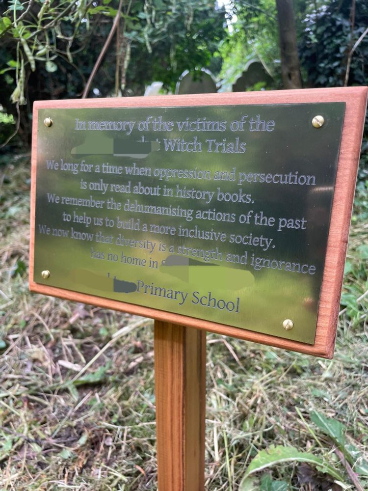 Plaque reading: In memory of the victims of the [redacted]
Witch Trials
We long for a time when oppression and persecution is only read about in history books. remember the dehumanising actions of the past to help us to build a more inclusive society.
We now know that diversity is a strength and ignorance has no home in [redacted].
[Redacted] Primary School