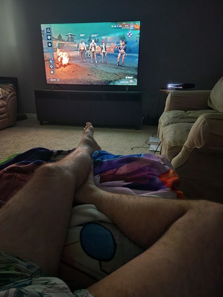 Laying on my couch. The video game dead by daylight is on my tv screen. 
