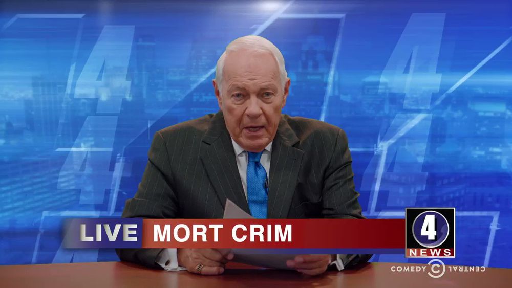Mort Crim on Detroiters, an old white man in a suit at a news desk, with the chyron LIVE - MORT CRIM