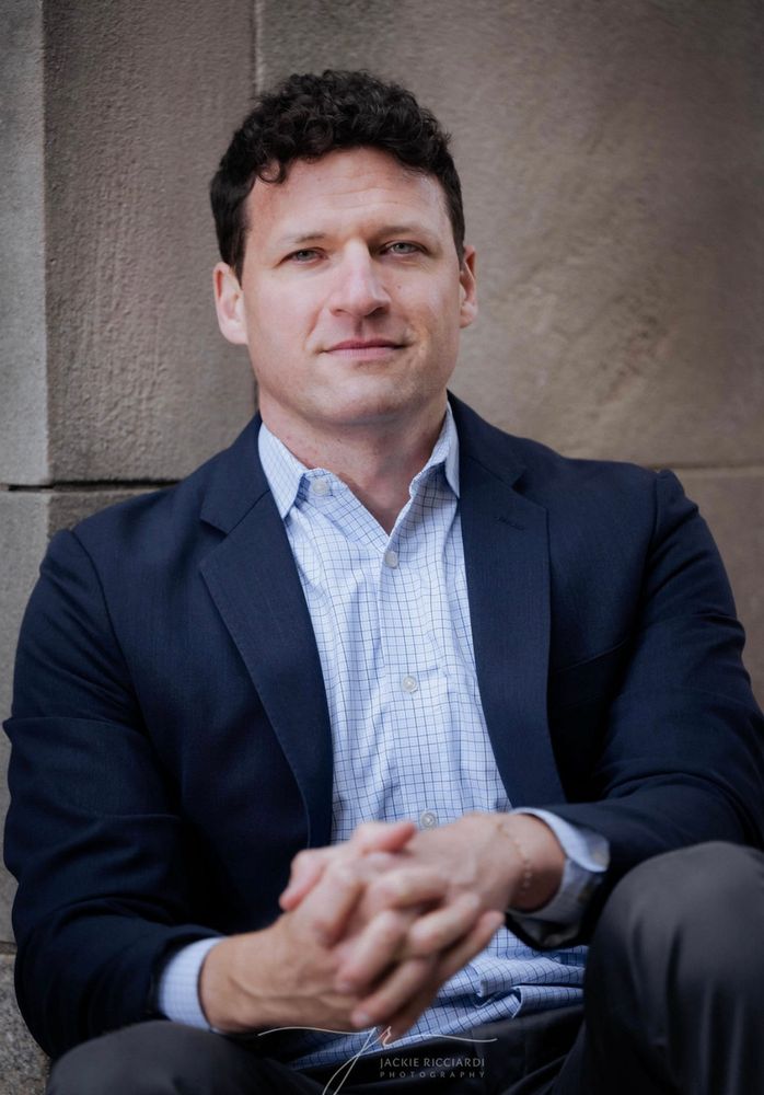 A picture of me sitting against a stone wall 