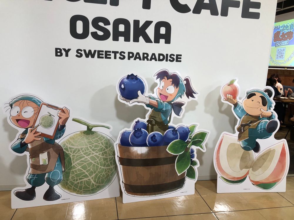 スイーツパラダイスの忍たま乱太郎コラボ。店舗入口に乱太郎、きり丸、しんべヱのパネルが置かれている。