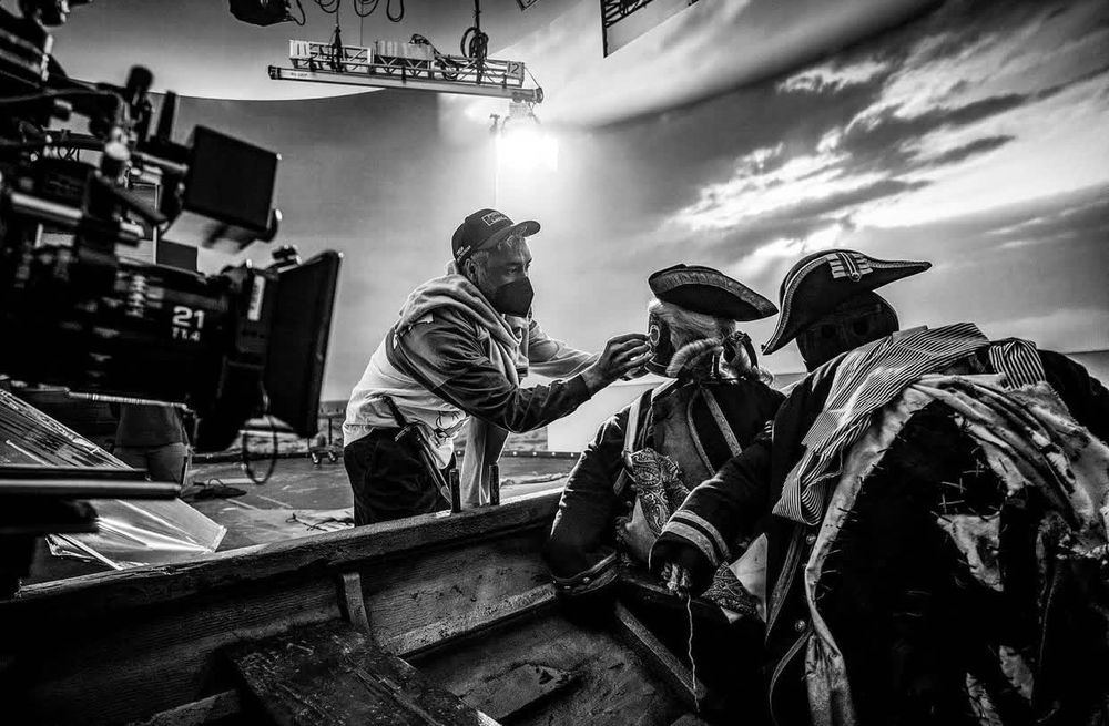 Taika Waititi is directing Our Flag Means Death. He’s drawing a face on a dummy in a rowboat. He is very hot, even though half his face is covered in a mask. He’s wearing his regular clothes, but also had Ed’s dagger on his belt. 