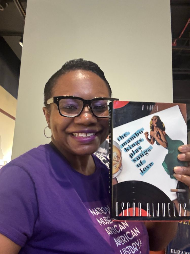 Me holding a copy of “The Mambo Kings Play Songs of Love” by Oscar Hijuelos at The American Writers Museum in Chicago. 