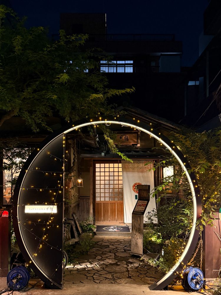 Im Hintergrund eine Schiebetür aus Holz und Reispapier, im Vordergrund ein Lichtkreis als Eingang zum Grundstück