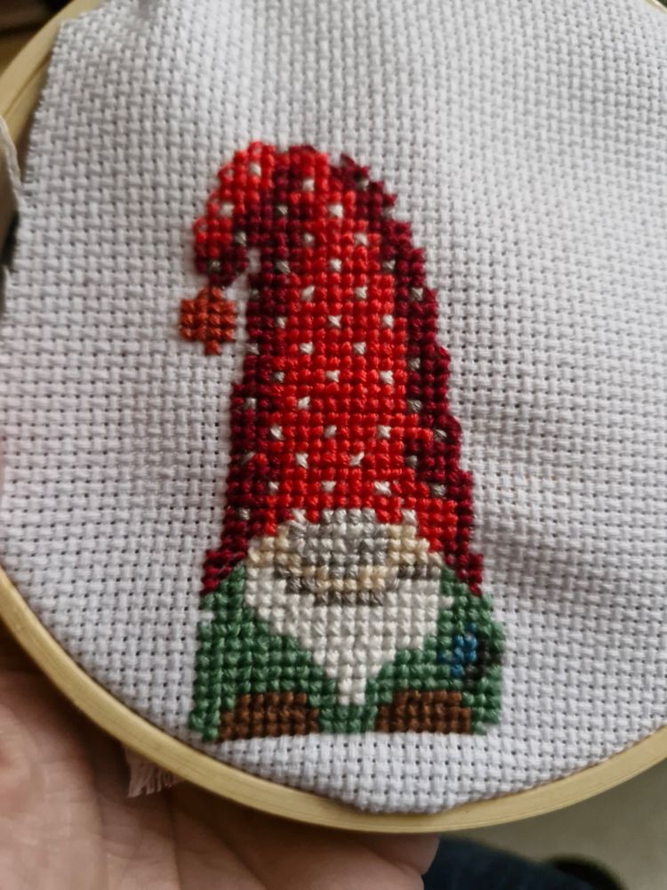 Gnome de Noël au point de croix habillé en vert, bonnet rouge et bottes marron 