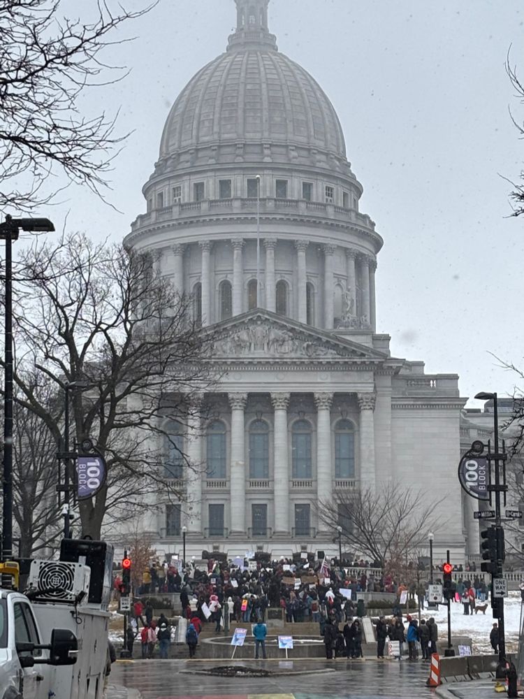 Wisconsin Capitol with close to 1000 people standing on the steps holding signs in favor of scientific research.