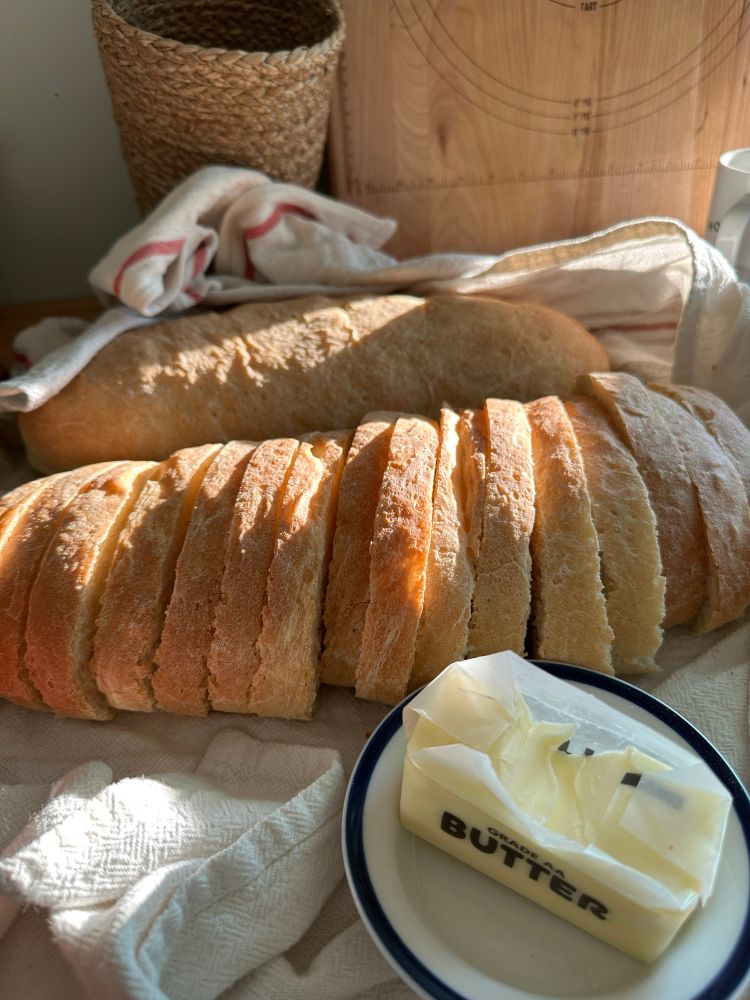 Sliced French bread with butter in a dish in the for ground 