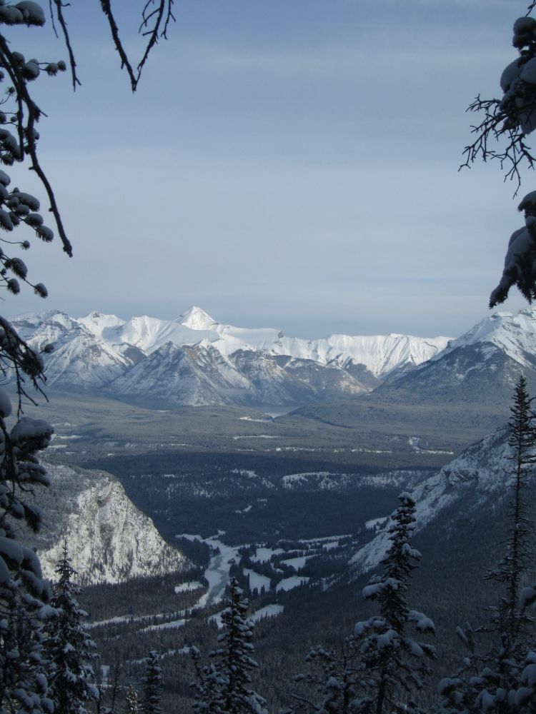 Tunnel Mountain and river Bow, seen from Sulphur Mountain hiking trail. One can see Lake Minnewanka in the distance. December 2022.