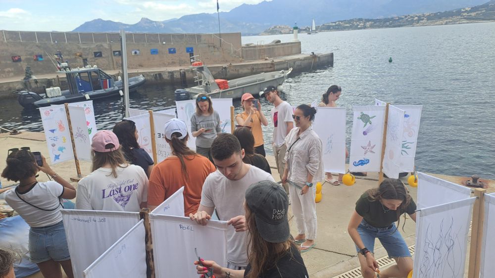 Students on the deck mounting the drifters. The sea to the right and mountains behind 