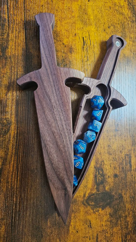 A wooden box shaped like a dagger with blue dice inside. 