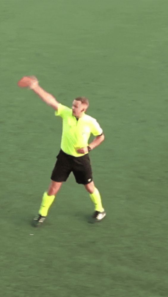 a man in a yellow shirt and black shorts is holding a frisbee in his hand