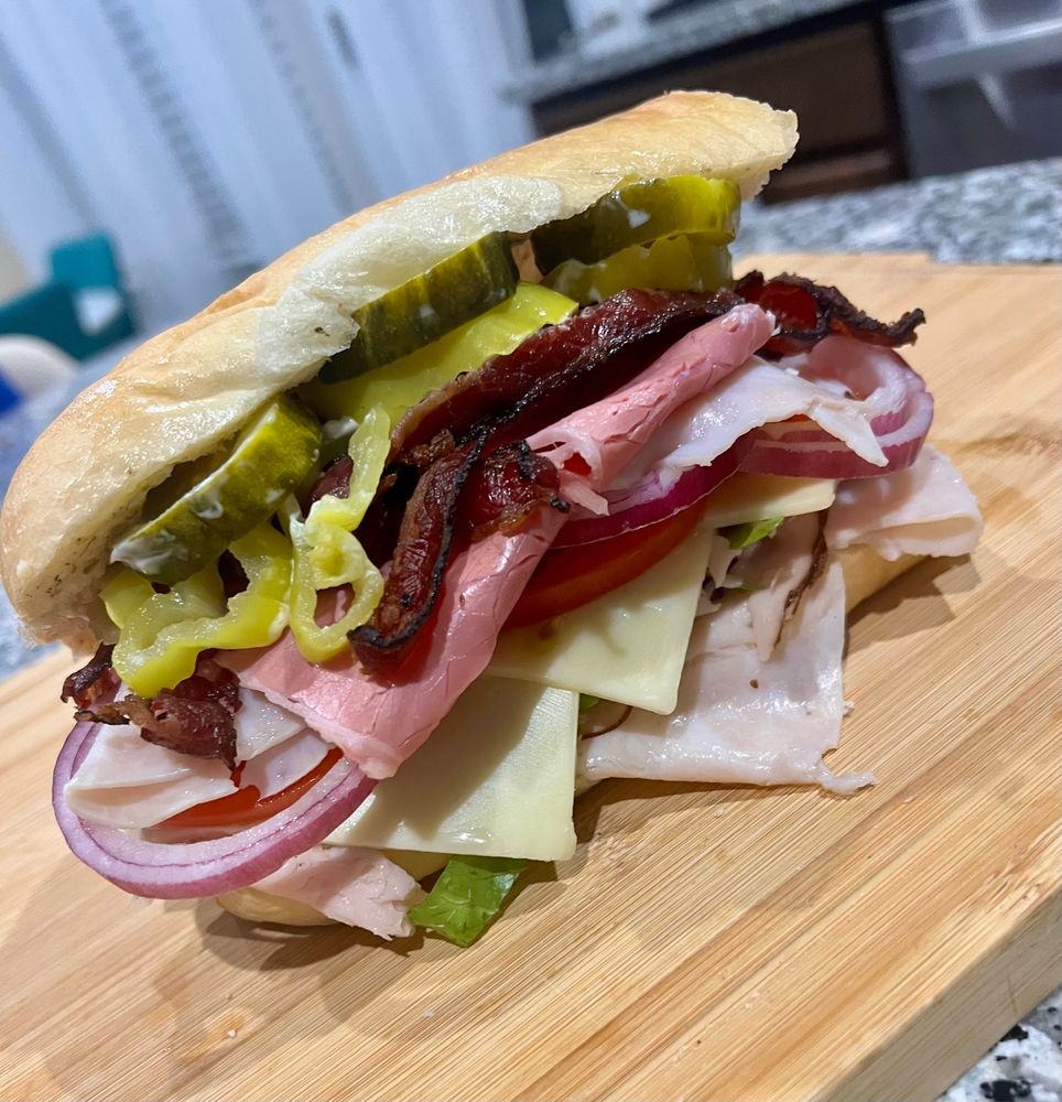 A Scooby Doo inspired sandwich that’s piled high with pickles, banana peppers, red onion, tomato, pastrami, turkey, beef bacon & Swiss cheese on a 6” long hoagie/sub roll.