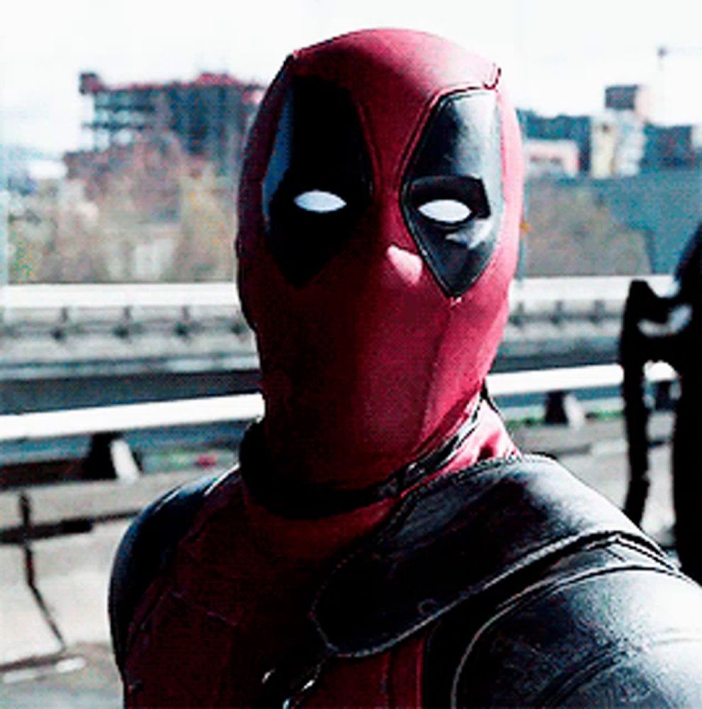 a man in a deadpool costume is standing in front of a bridge