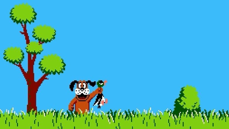A pixelated image from the 1984 Nintendo game Duck Hunt with a bright cerulean sky, green grass, a tall green and brown tree and a brown hound dog holding up a green mallard duck.
