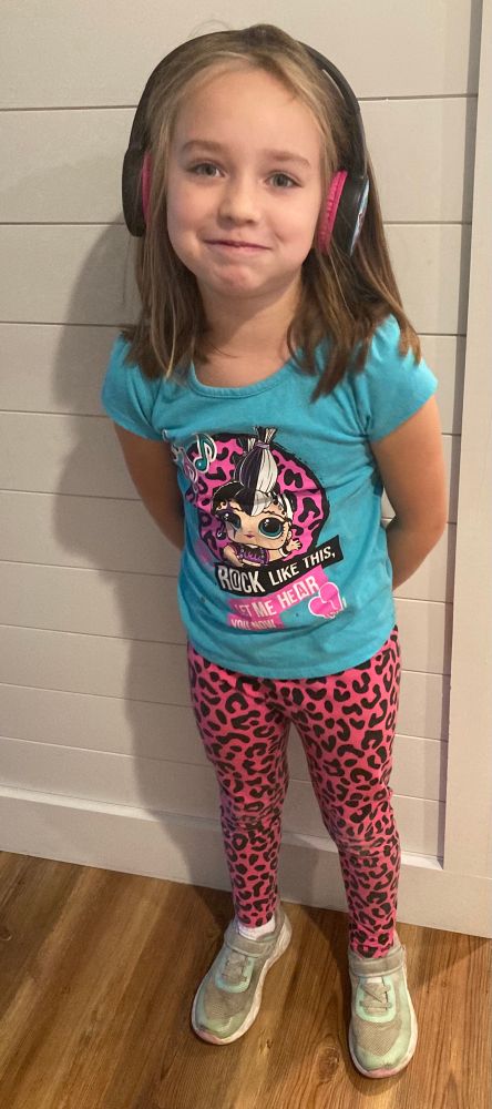 My 7yo daughter wearing an L.O.L. Doll outfit and headphones