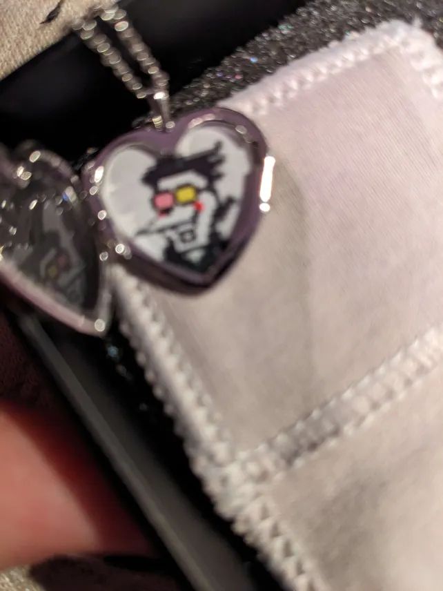 The inside of the locket, with a picture of Spamton