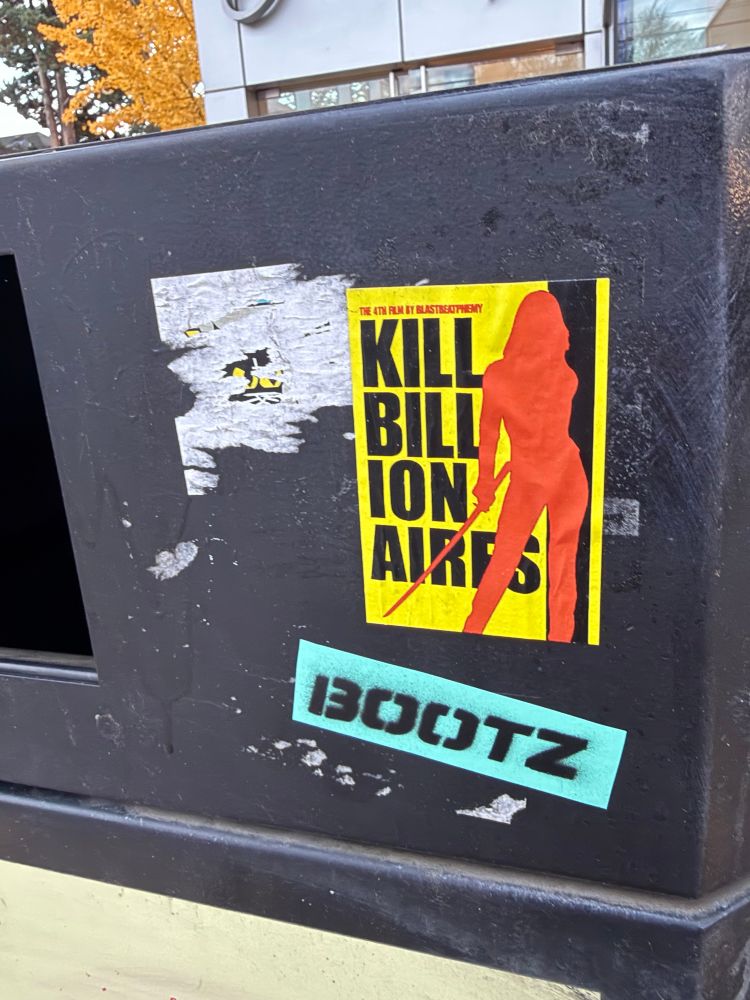 A sticker on a trash bin of the iconic “Kill Bill” poster, but continues to say “Kill Billionaires”.
