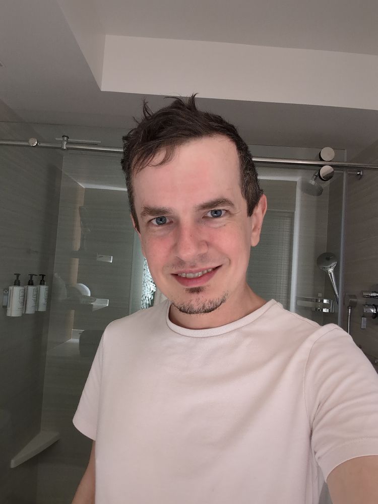 A selfie of me smiling in the mirror of a hotel bathroom.