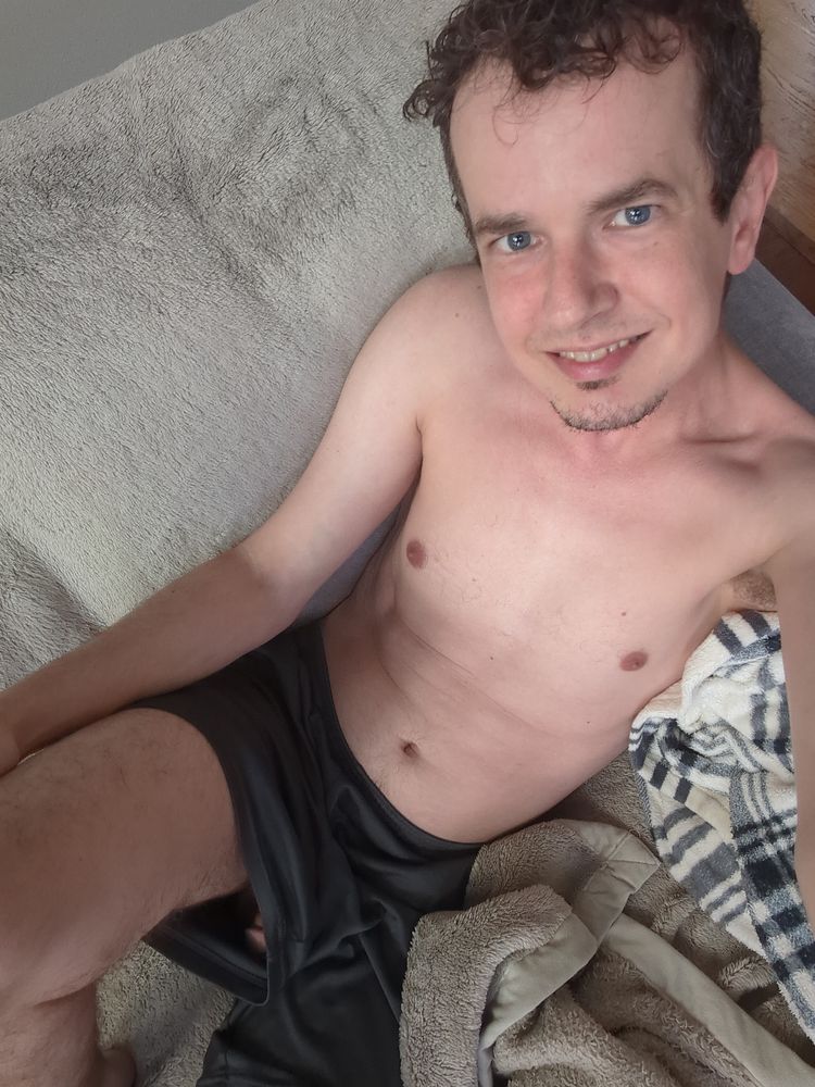 Another selfie picture in a slightly different pose, where just a tease of the tip of my penis can be seen up my shorts, while my face looks up at the camera with a smile.